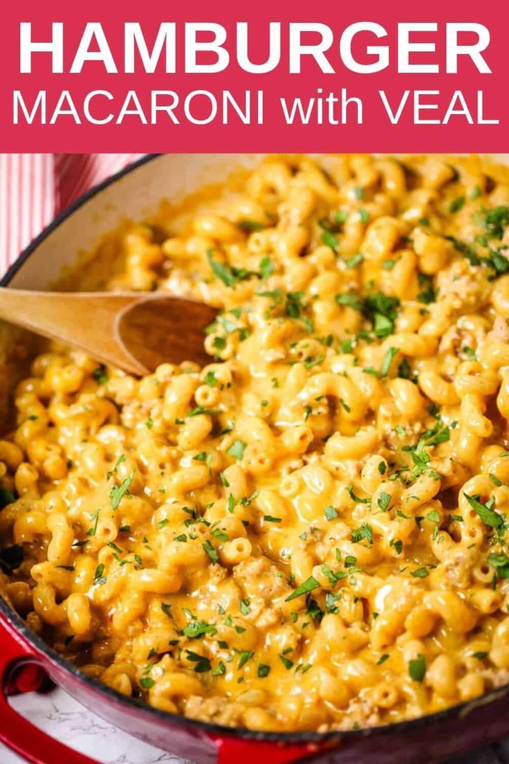 a red skillet filled with macaroni and cheese, topped with parsley