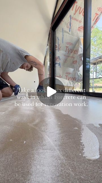 a man is working on the floor in front of a window with an advertizer