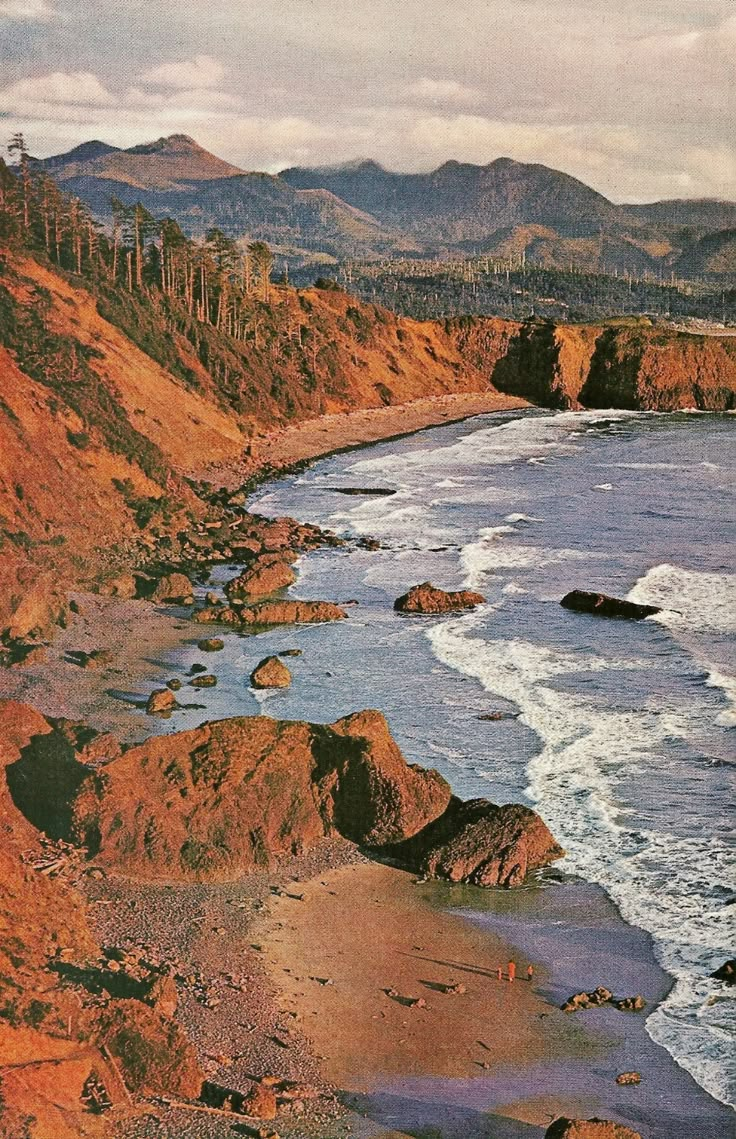 an ocean view with mountains in the background and waves crashing on the shore, as seen from above