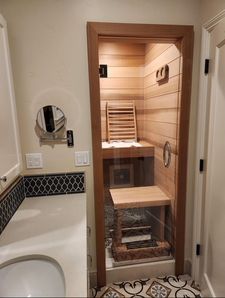 an empty sauna in a bathroom next to a sink