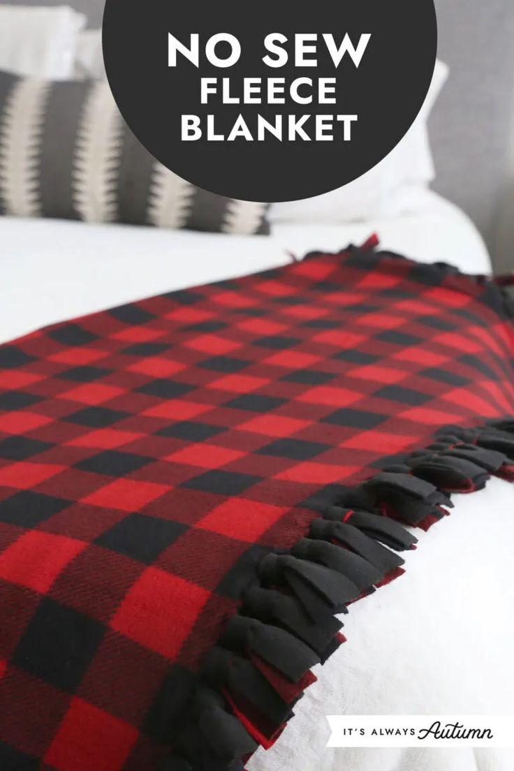 a red and black blanket sitting on top of a bed with the words no sew fleece blanket