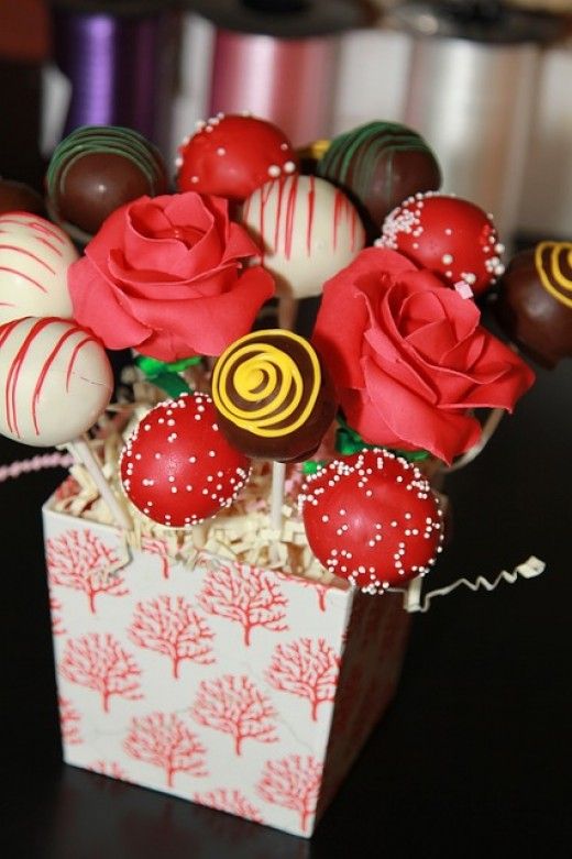 a box filled with chocolate covered strawberries and candy roses on top of a table