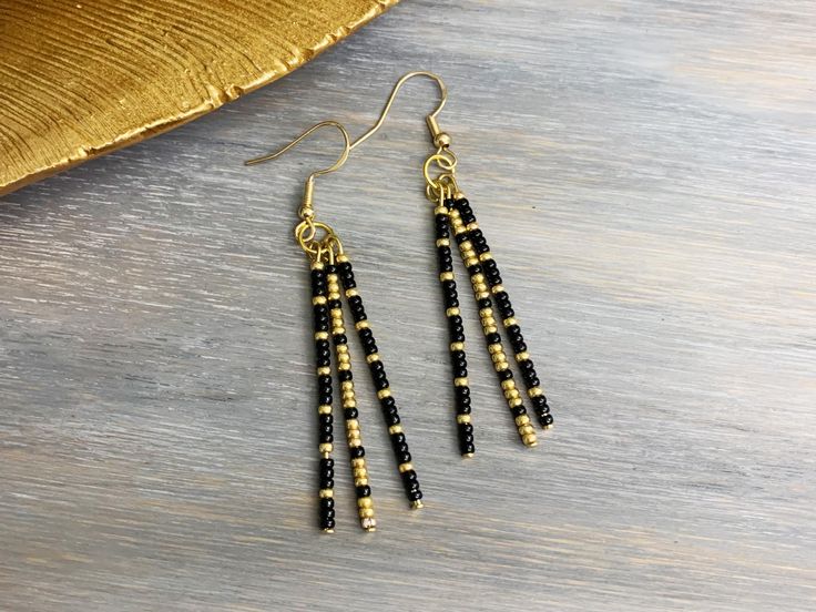 These simple dangling stick earrings are lightweight and stylish. The black and gold beads are perfect for every day use and any outfit! These earrings contain 3 beaded head pins with varying black and gold pattern.  Details: Miyuki seed beads are individually placed on each straight head pin. The straight pins are then curved and placed on a jump ring. Beads may move a little along pin and the beaded pins will move independently of one another. As each piece is 100% handmade, they are unique an Head Pins Jewelry, Beaded Pins, Gold Bead Earrings, Stick Earrings, Pin Earrings, Diy Jewlery, Diy Jewelry Unique, Earring Wire, Straight Pins