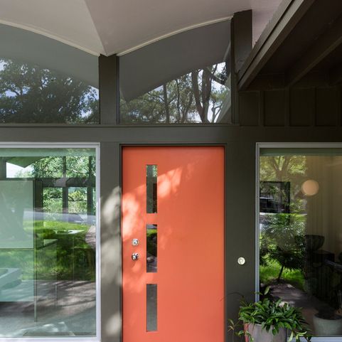 an orange front door with glass panels on the side