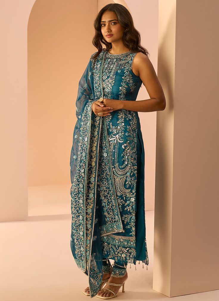 Our Dark Teal Embroidered Straight Suit includes a net top with satin inner, satin bottom, and a net dupatta. Embroidery is present on this style using zari, sequins, and stone work. Like all of our pieces, this piece is made in India and checked by hand to ensure high quality. Sleeveless Salwar Kameez For Eid Reception, Sleeveless Organza Sets For Eid, Silk Churidar With Mirror Work For Reception, Semi-stitched Sleeveless Salwar Kameez With Sheer Dupatta, Unstitched Sleeveless Salwar Kameez With Sheer Dupatta, Sleeveless Traditional Wear With Sheer Dupatta For Festive Occasions, Festive Sleeveless Traditional Wear With Sheer Dupatta, Festive Sleeveless Salwar Kameez With Sheer Dupatta, Silk Unstitched Suit For Reception And Navratri