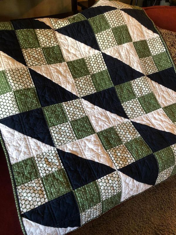 a green and black quilt on the floor