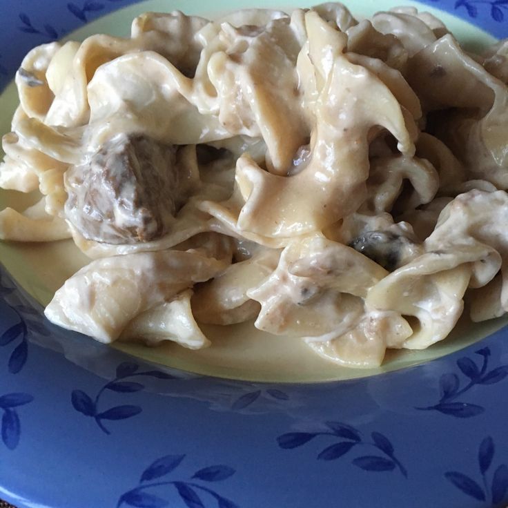 a blue plate topped with pasta and meat