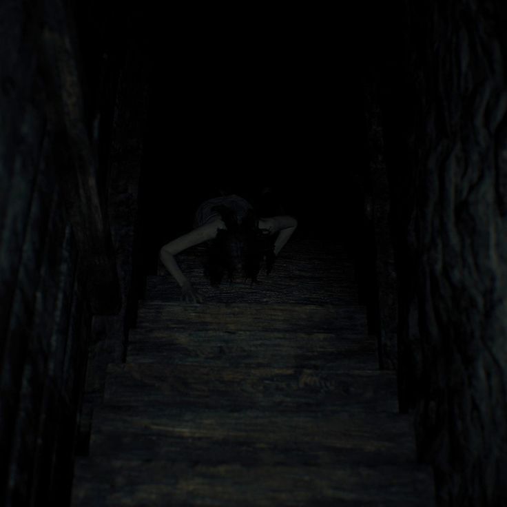 a woman is kneeling down in the dark with her head on her knees and arms behind her back