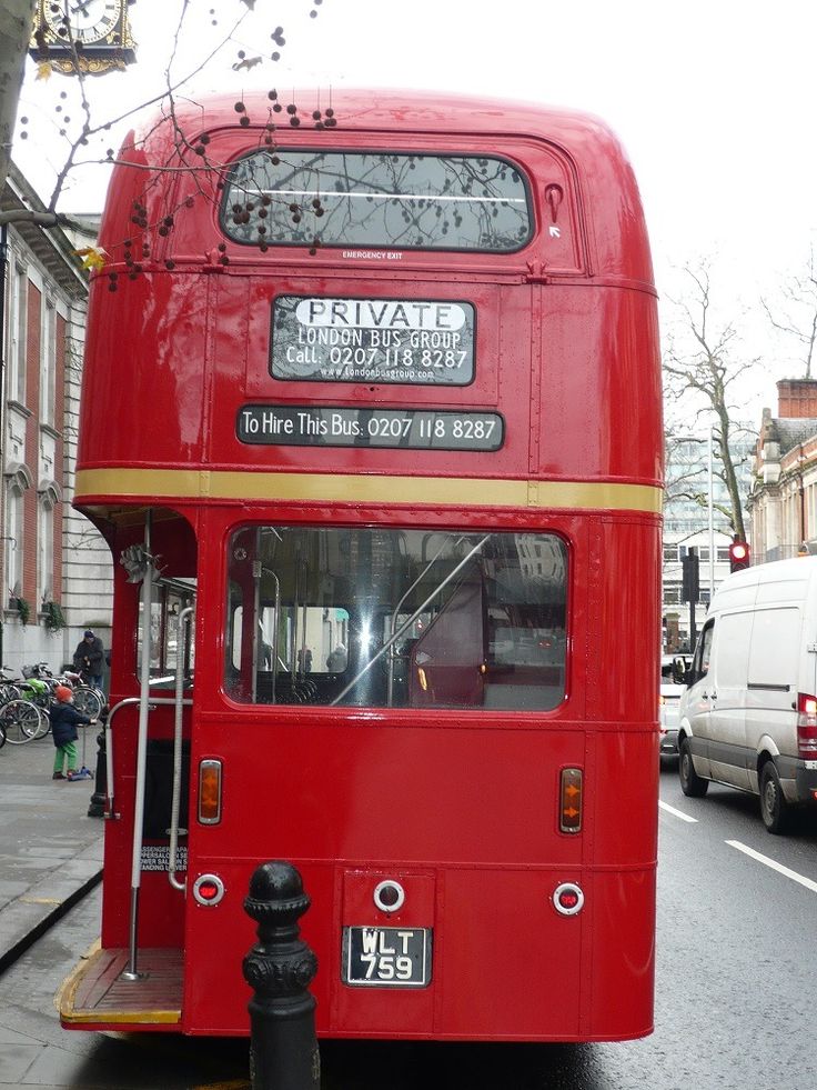 a red double decker bus parked on the side of the road next to a fire hydrant