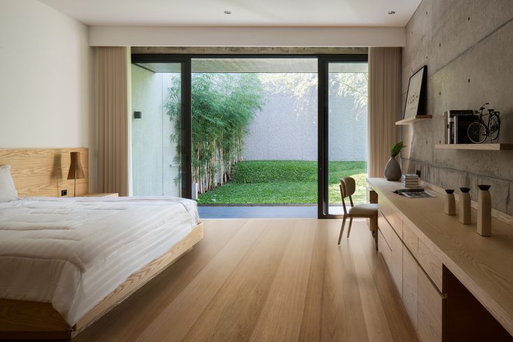 a bedroom with wooden floors and sliding glass doors