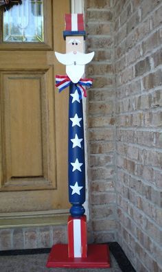 a patriotic flag pole with a man on it in front of a brick wall and door