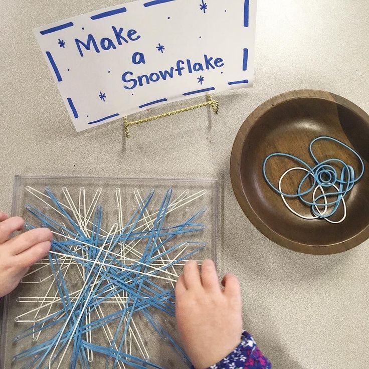 someone is making a snowflake out of clothes pins and plastic straws in front of a sign that says make a snowflake