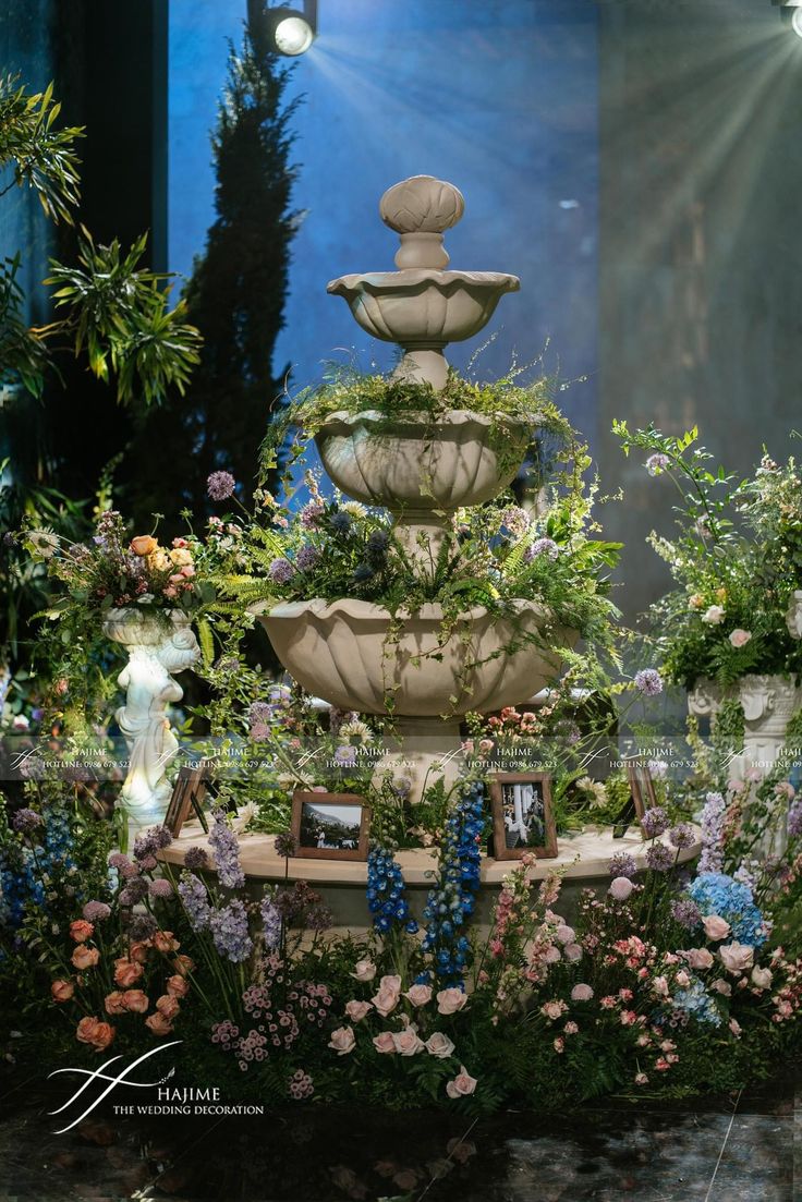 a large fountain surrounded by flowers and plants