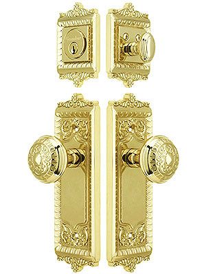 two golden door handles and knobs on a white background