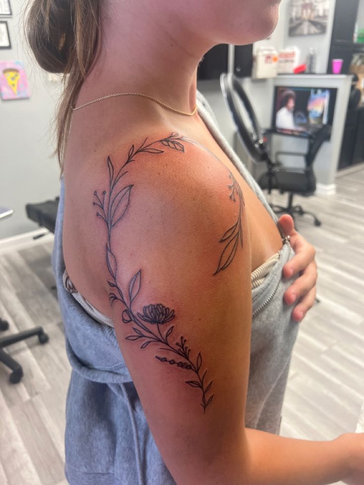 a woman with a flower tattoo on her shoulder