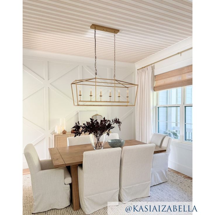 a dining room table with four chairs and a chandelier hanging from the ceiling