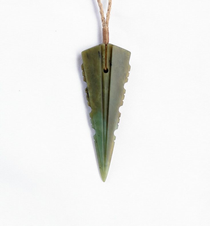 an arrow shaped pendant hangs on a string