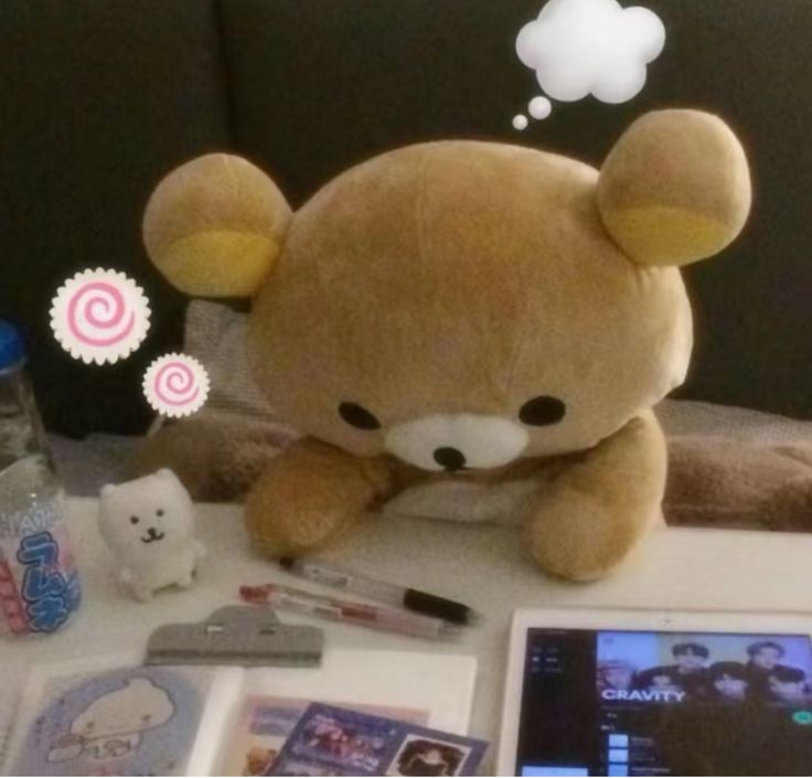 a teddy bear sitting on top of a table next to other toys and items in front of it