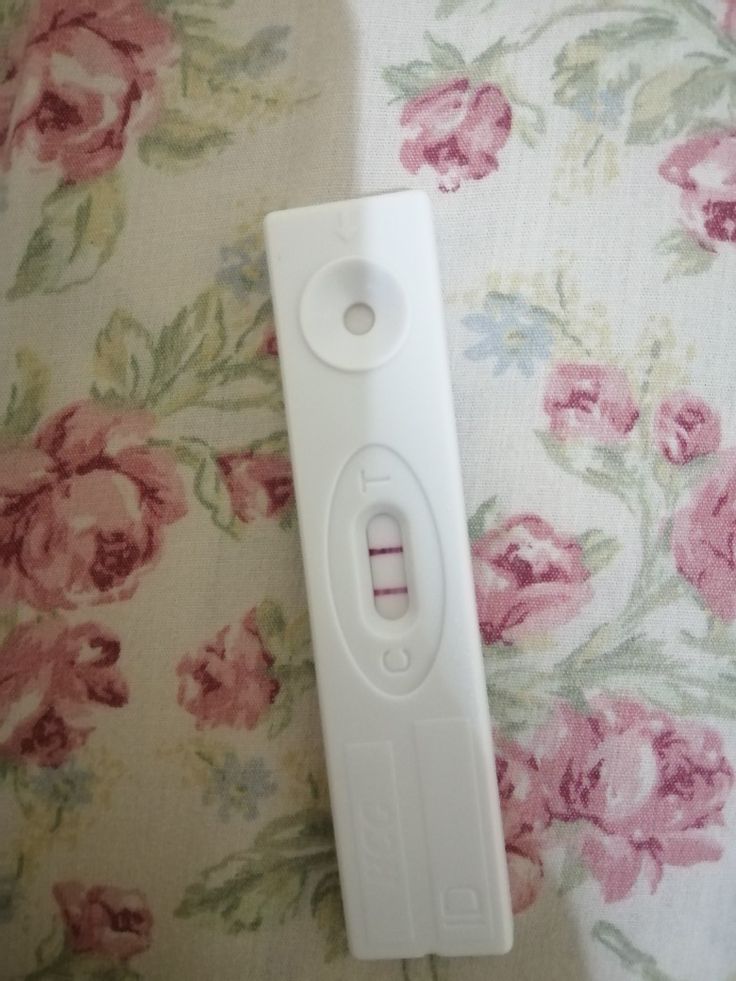 an electronic device laying on top of a floral print bed spread with pink and white flowers