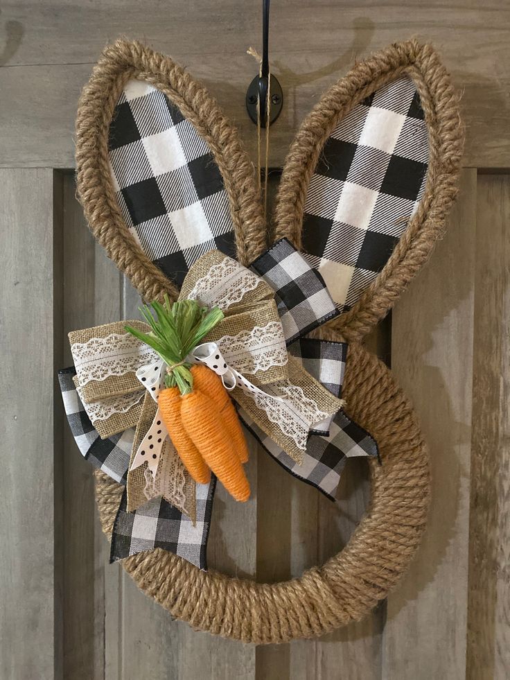 a door hanger decorated with an easter bunny's head and two carrots