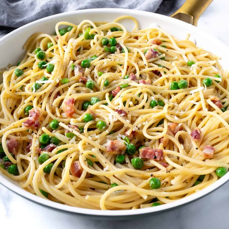 a white bowl filled with pasta and peas