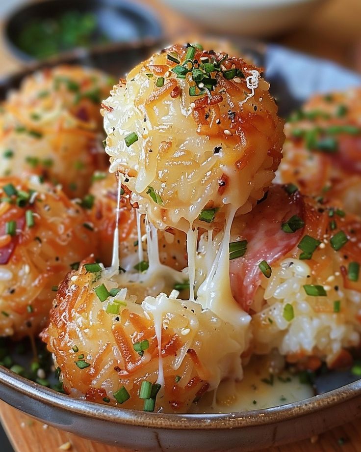 a close up of food in a bowl with cheese and meatballs on the side