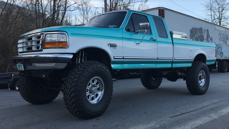 a blue and white truck is parked on the street