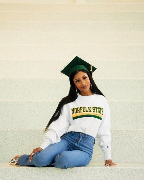 a young woman sitting on the steps wearing a mortar cap and jeans with her legs crossed