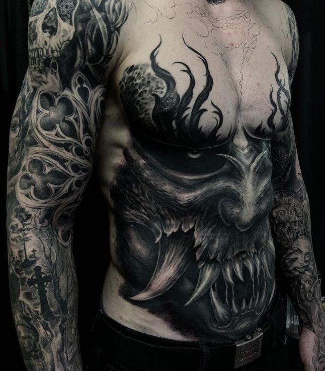 a man with tattoos on his chest is posing for the camera