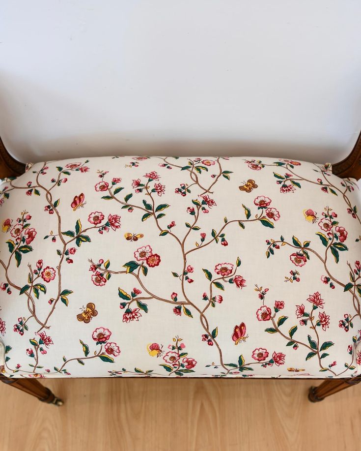 an upholstered bench with floral fabric on it