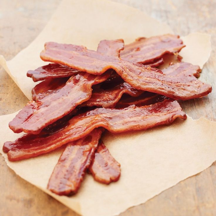 some bacon is sitting on top of a piece of parchment paper