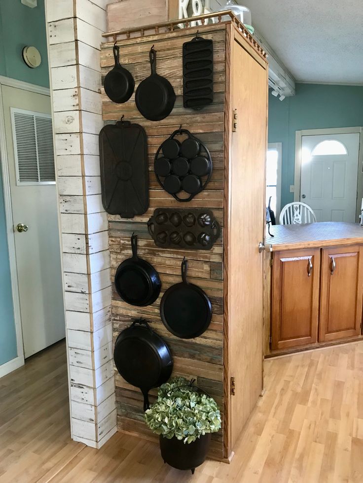 pots and pans are hanging on the wall in this kitchen area with wood flooring