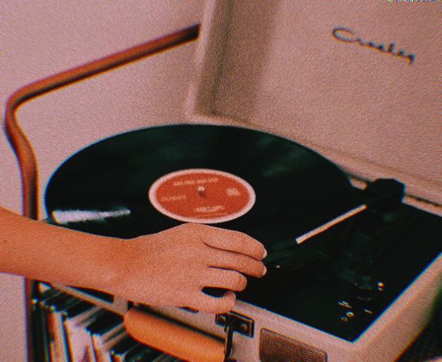 a person is holding a record player and pressing it on the turntable with their hand