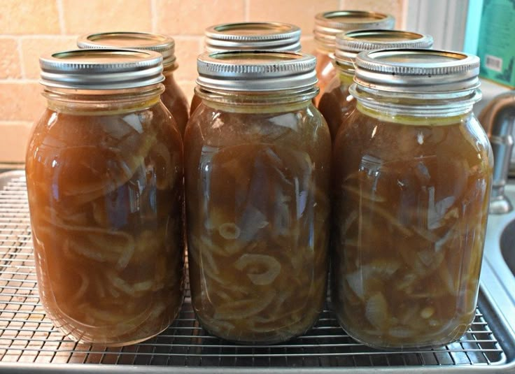 four jars filled with food sitting on top of a metal rack