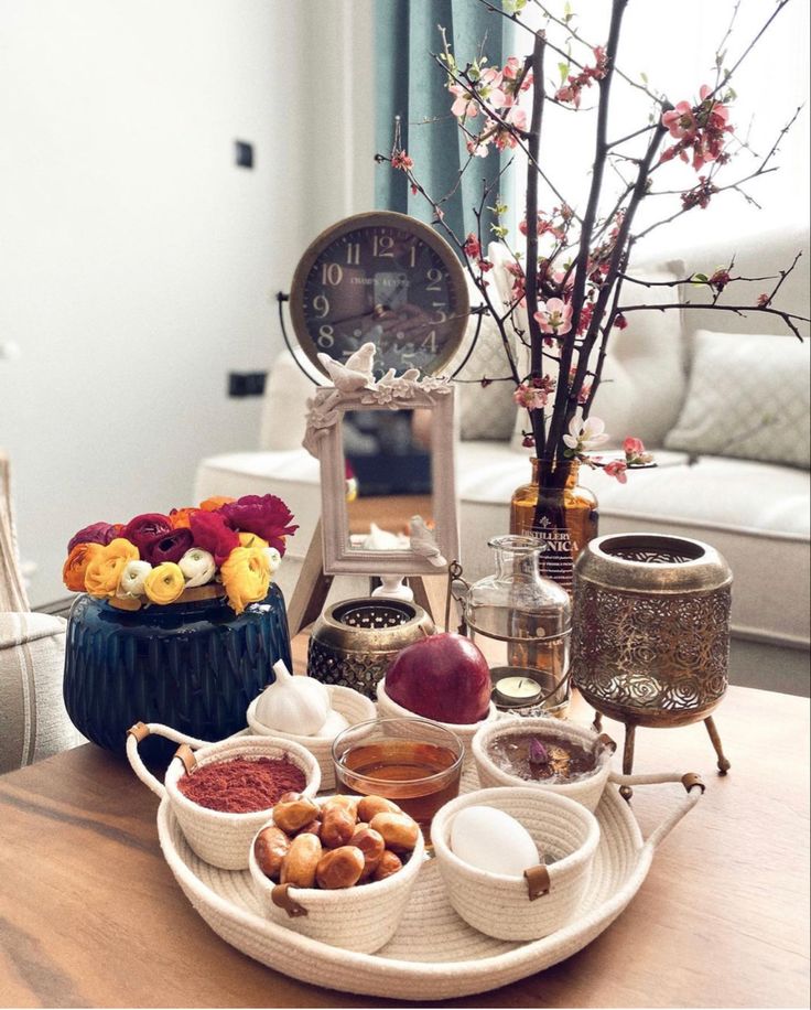 a table topped with bowls filled with different types of food next to a clock on top of a wooden table