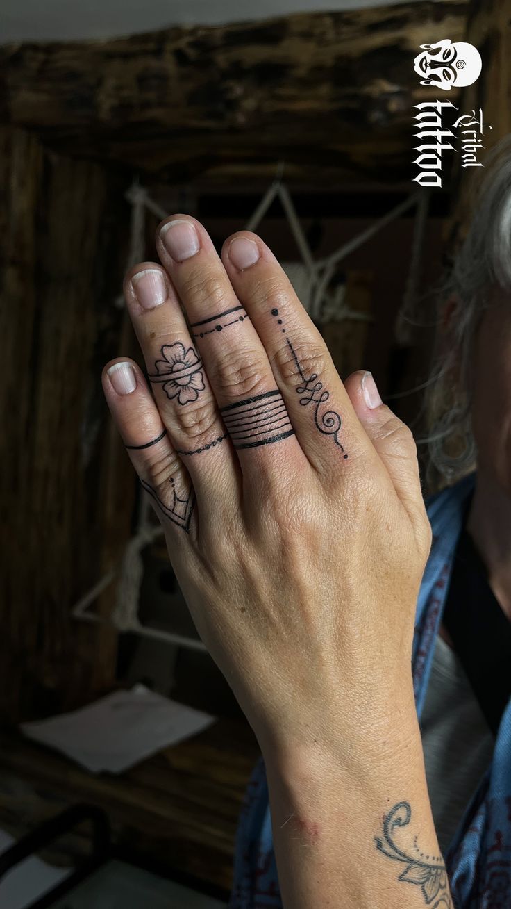 a woman holding her hand up with two rings on it