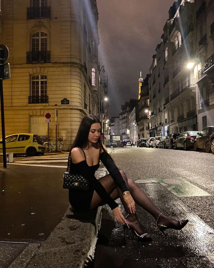 a woman sitting on the side of a street