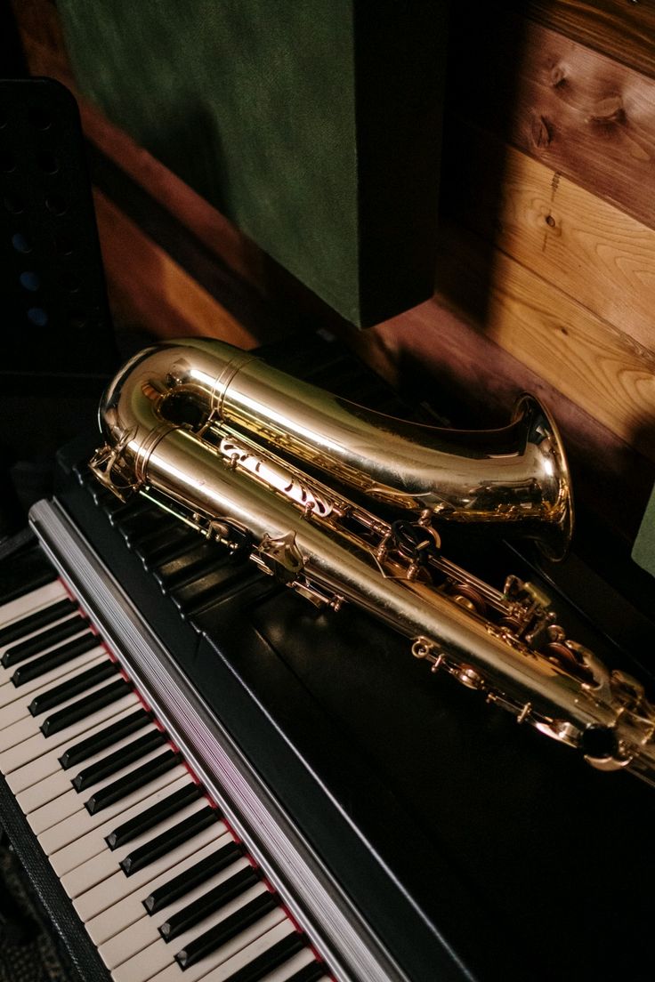 a golden saxophone sitting on top of a piano