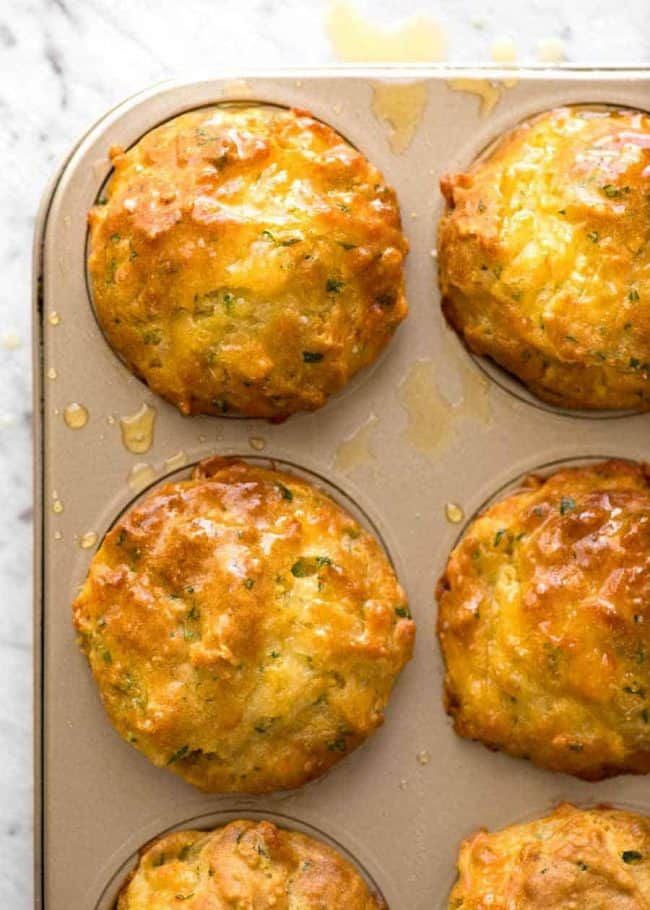 baked muffins in a baking pan on a marble counter top, ready to go into the oven