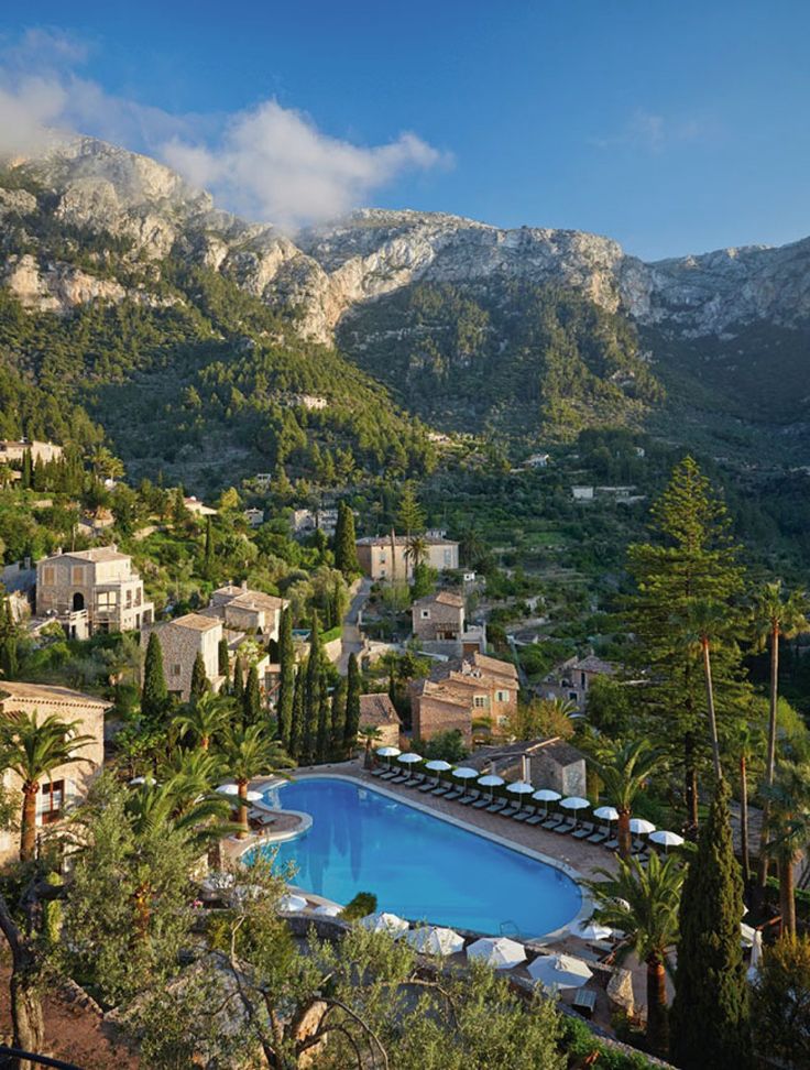 an outdoor swimming pool surrounded by trees and mountains