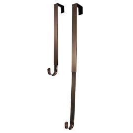 a pair of metal hooks hang from the wall on an iron rod, which is also attached to a door handle