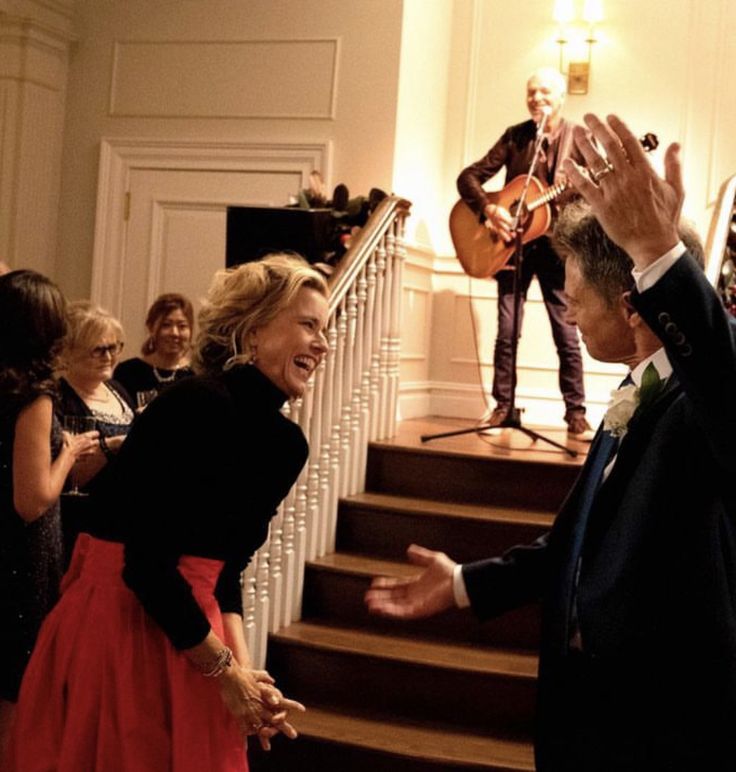 a group of people standing around each other in front of a stair case with musical instruments