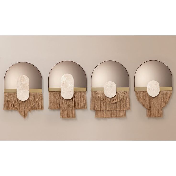 four round mirrors with tassels hanging on the wall