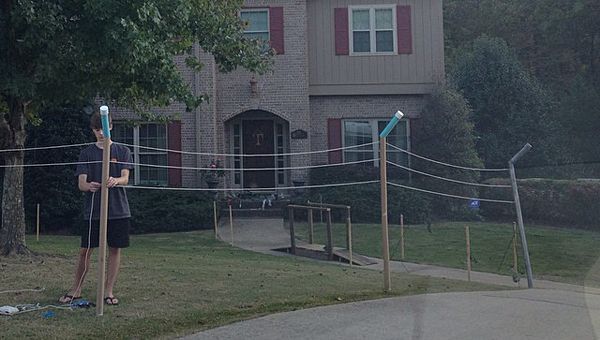 a man holding a baseball bat in front of a house on a foggy day