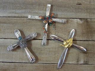 three metal crosses sitting on top of a wooden table