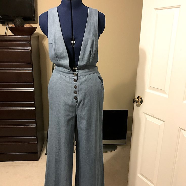 Light Blue Denim Wide Leg Jumpsuit With Side Pockets. Fitted Light Wash Pants For Work, Workwear Medium Wash Overall Bottoms, Workwear Medium Wash Overalls, Blue High Waist Denim Jumpsuit For Work, Washed Blue Fitted Overalls, Blue Denim Overall Pants, High Waist Blue Overalls For Workwear, High-waisted Blue Overalls For Workwear, Blue High-waist Overalls For Work