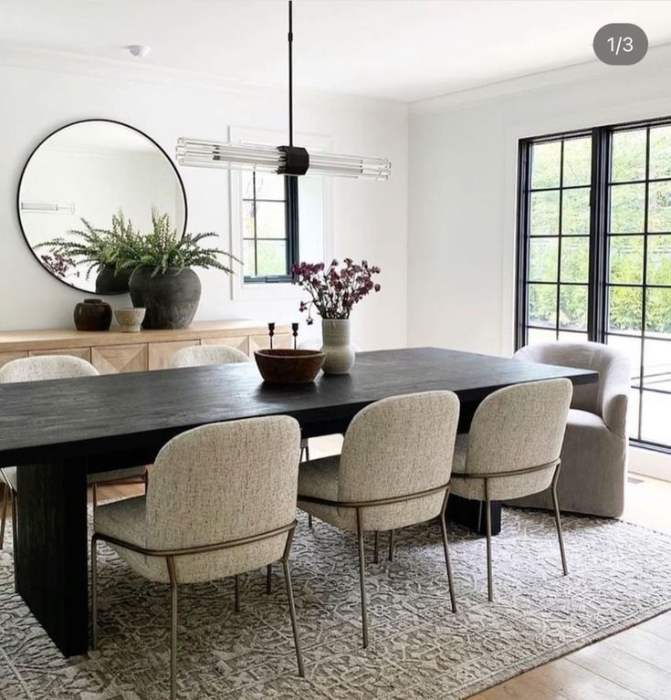 a dining room table with chairs and a mirror