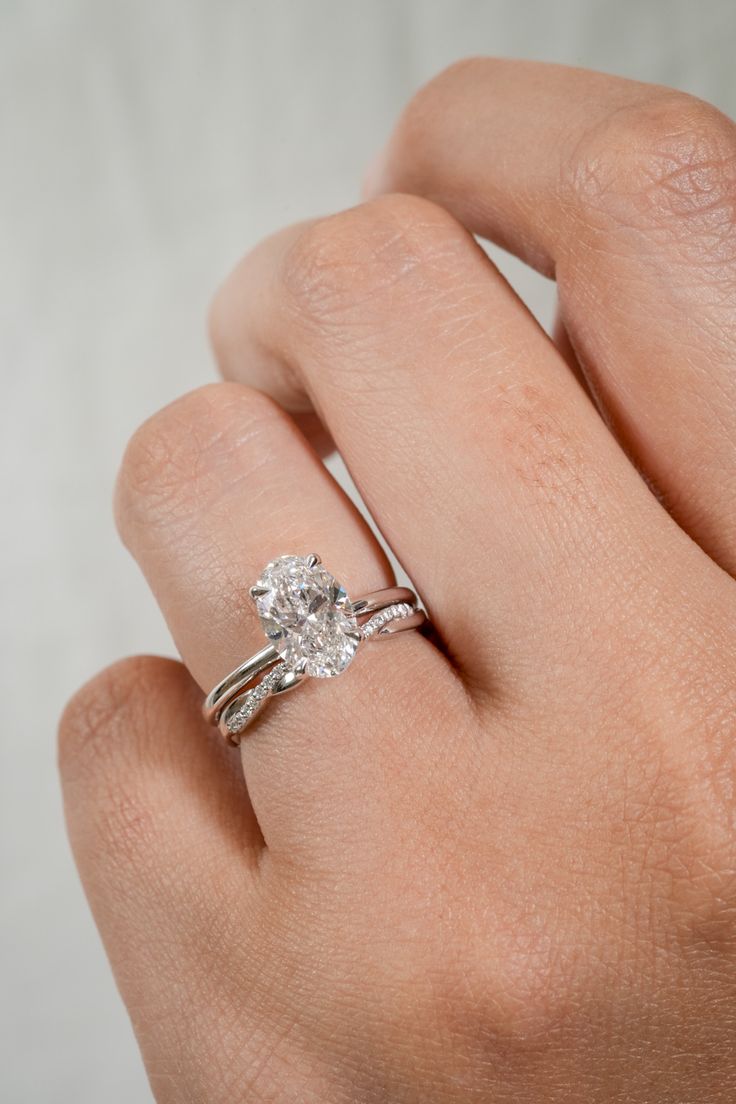 a woman's hand with a diamond ring on her left and an engagement band on her right