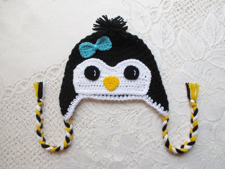 a crocheted penguin hat with a bow on it's head and ear