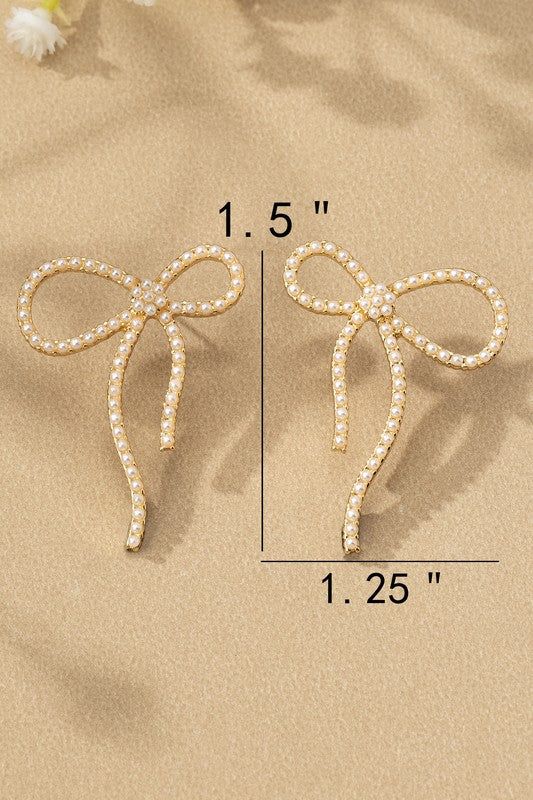 the measurements for two pairs of bow clip earrings on sand with flowers in background and text below